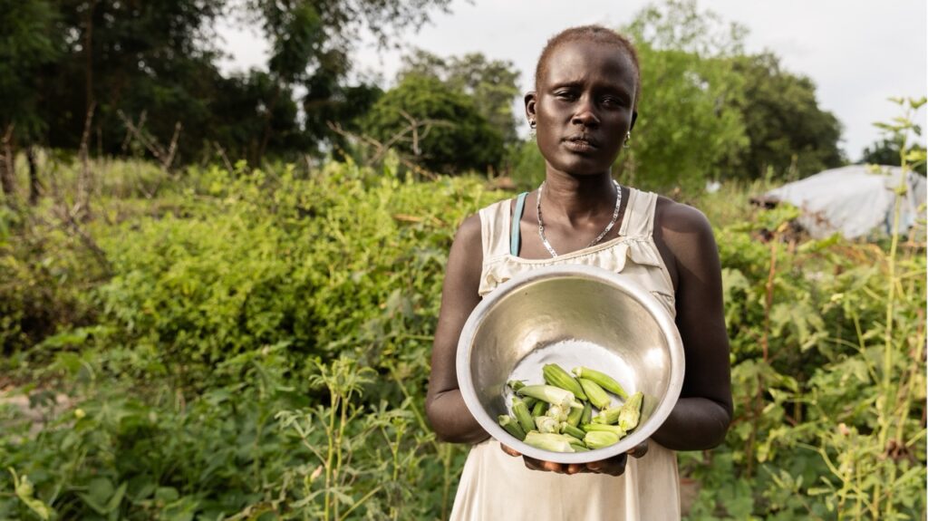 Nyalual Mathieng holds a bowl of freshly harvested okra in her vegetable garden in Ayod, South Sudan.