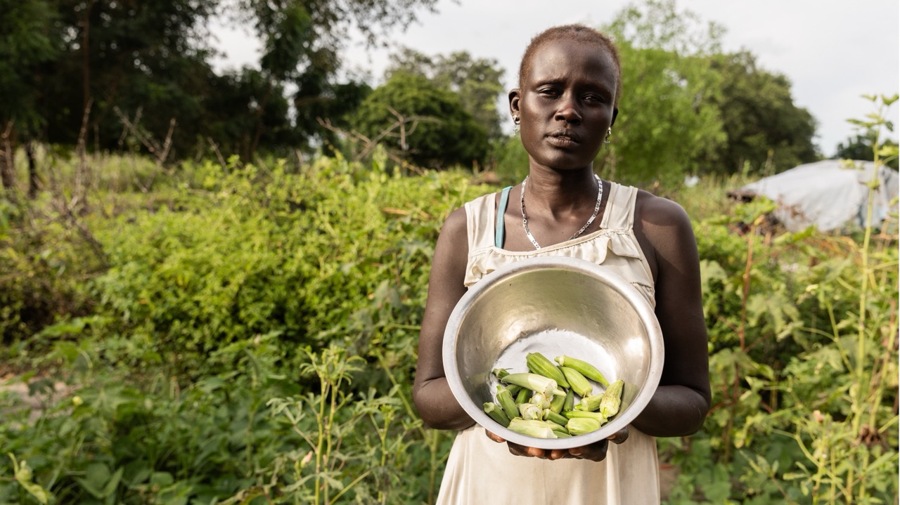 Nyalual Mathieng holds a bowl of freshly harvested okra in her vegetable garden in Ayod, South Sudan.